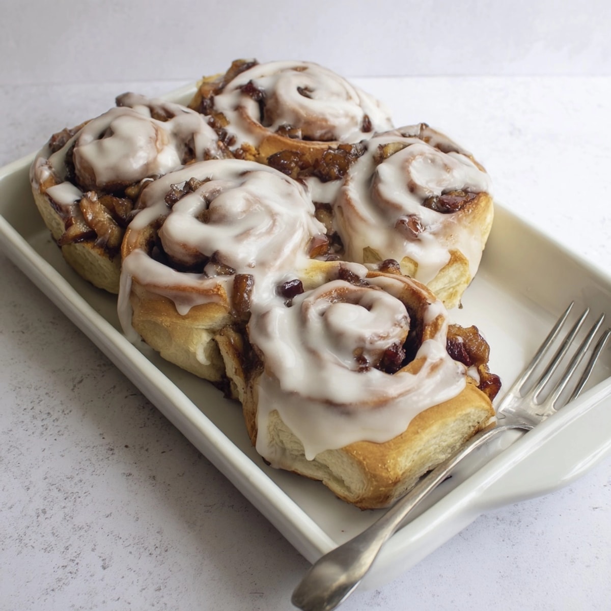 Overhead shot of warm, gooey Apple Cinnamon Rolls, ready to be enjoyed as dessert.