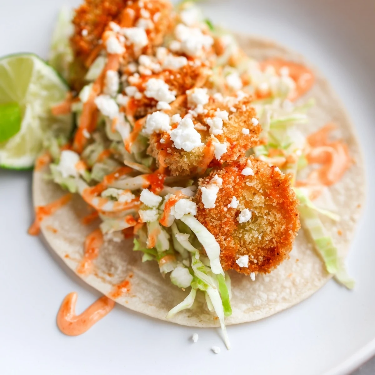 Golden fried pickles nestled in tortillas, drizzled with sweet chili sauce, and slaw.