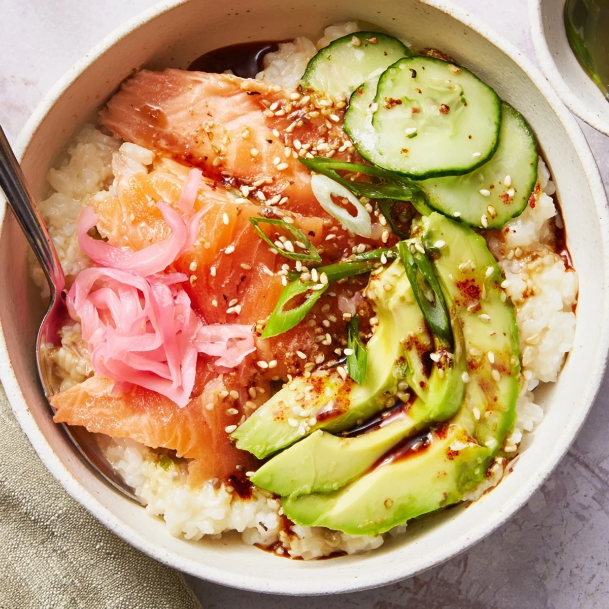 A vibrant Leftover Salmon & Rice Bowl topped with fresh avocado and cucumber.  