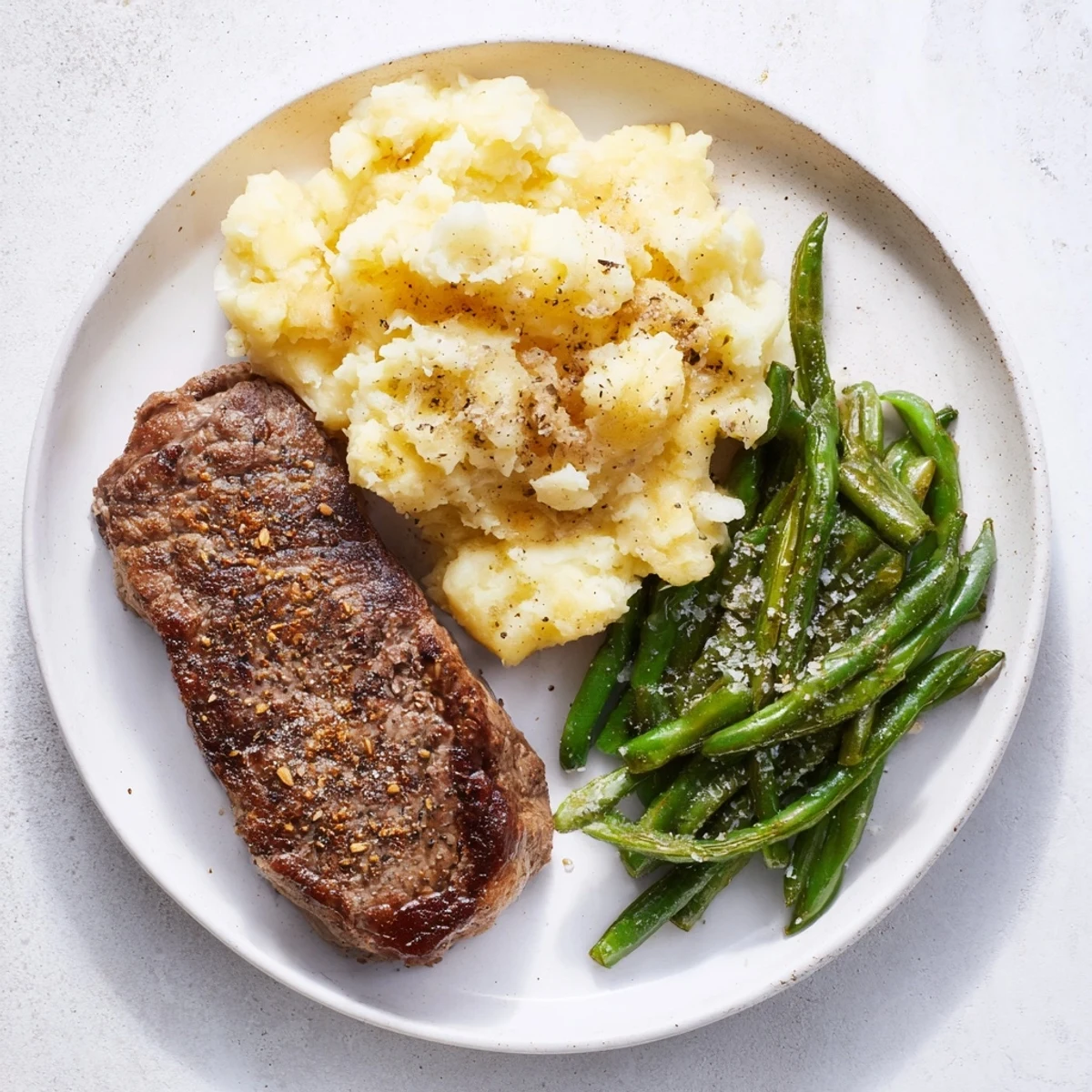 Sheet pan steak and garlic mash dinner with tender steak and creamy garlic mashed potatoes, ready to eat.