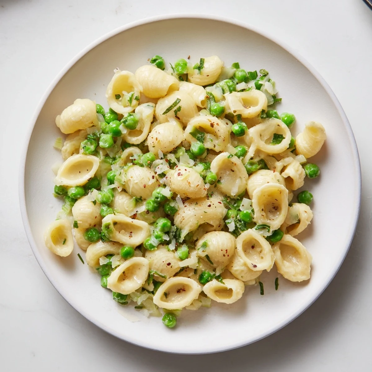Steaming bowl of Macaroni & Peas, a creamy, comforting pasta dish ready to eat.