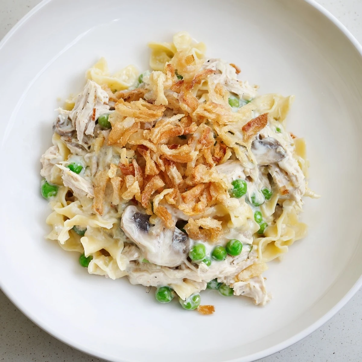This close-up shows a comforting Creamy Tuna Noodle Casserole with a spoonful ready to serve.