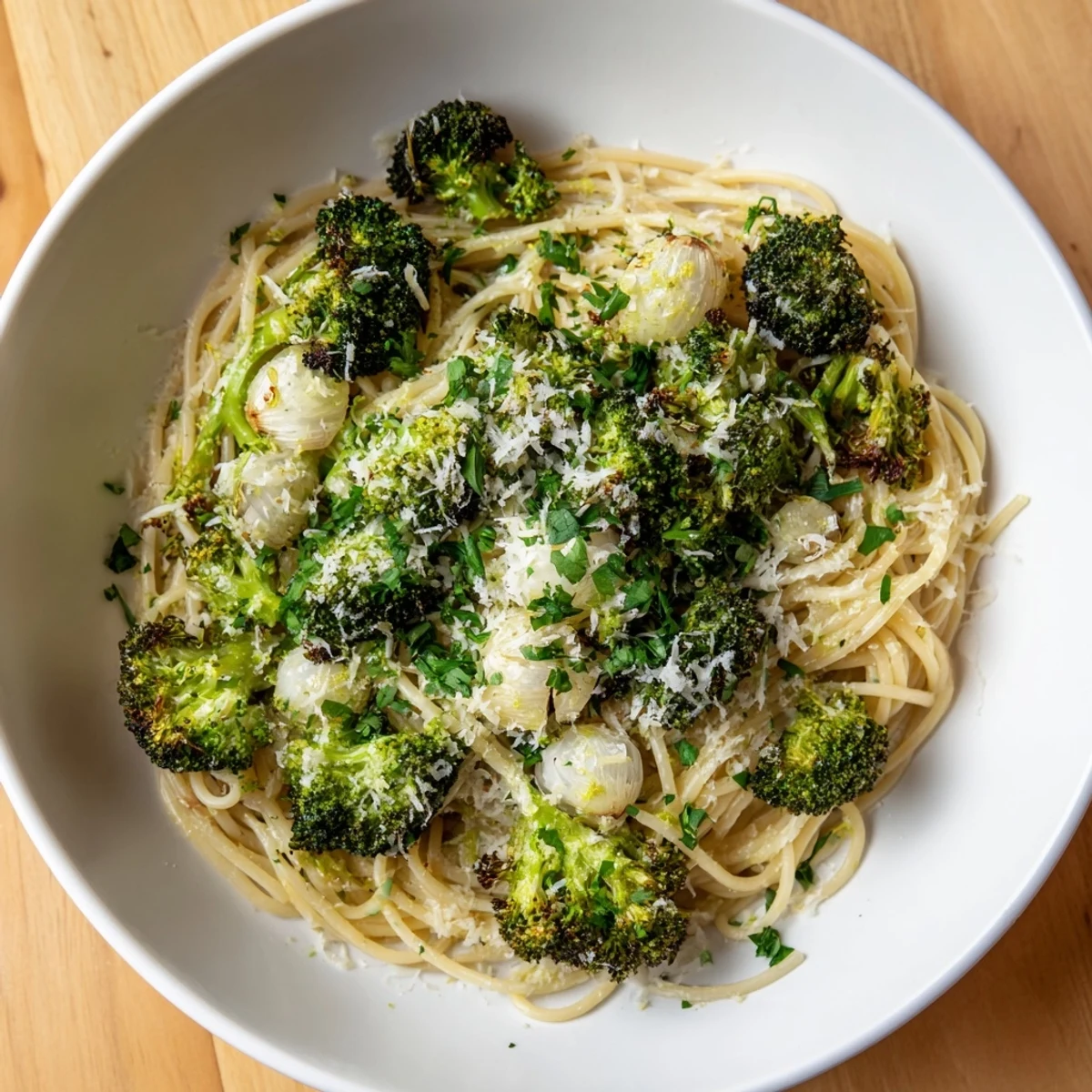 A bowl of flavorful roasted garlic lemon broccoli angel hair pasta, ready to serve with Parmesan.
