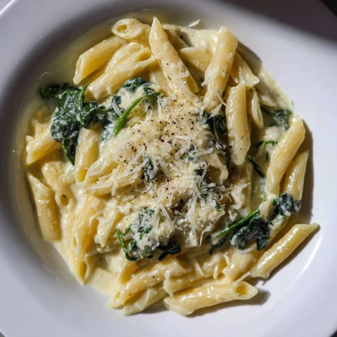 A bowl of Cottage Cheese Creamy Spinach Pasta, swirling with a rich, vibrant green sauce.