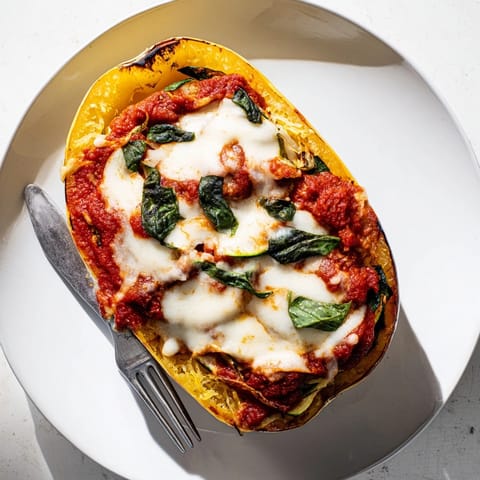 Golden brown Roasted Garlic Spaghetti Squash Lasagna Boats with melted mozzarella, fresh basil garnish.