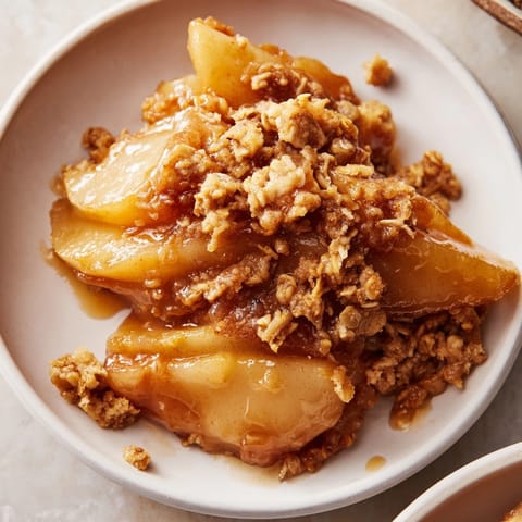 Buttery Cinnamon Caramel Pear Crumble, warm and fragrant, ready to serve with vanilla bean ice cream.