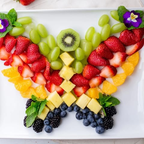 Freshly assembled Butterfly Bloom Fruit Board bursts with vibrant colors, perfect for a healthy and festive snack.