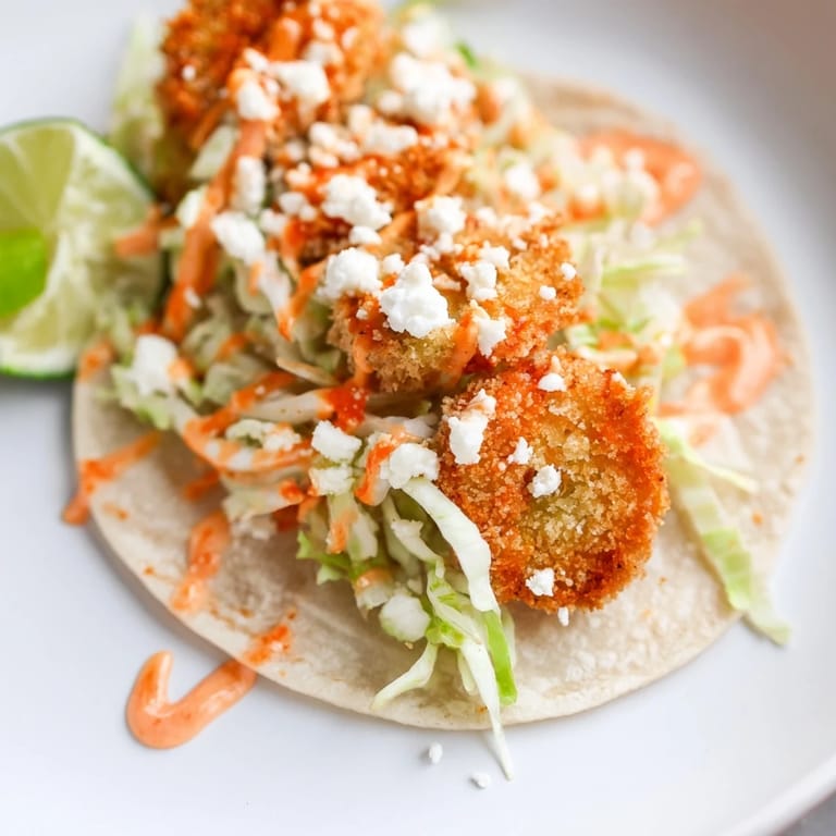 Golden fried pickles nestled in tortillas, drizzled with sweet chili sauce, and slaw.