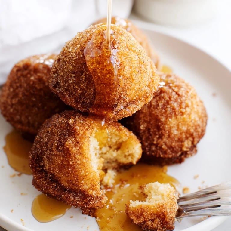 Golden-brown biscuit muffin balls filled with sharp cheddar and crystallized ginger delightfully coated.