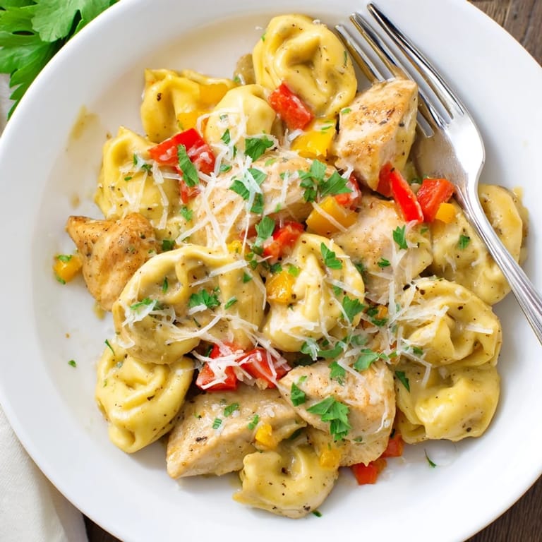 A deliciously vibrant bowl of Zesty Cajun Garlic Parmesan Chicken Tortellini ready to serve.  