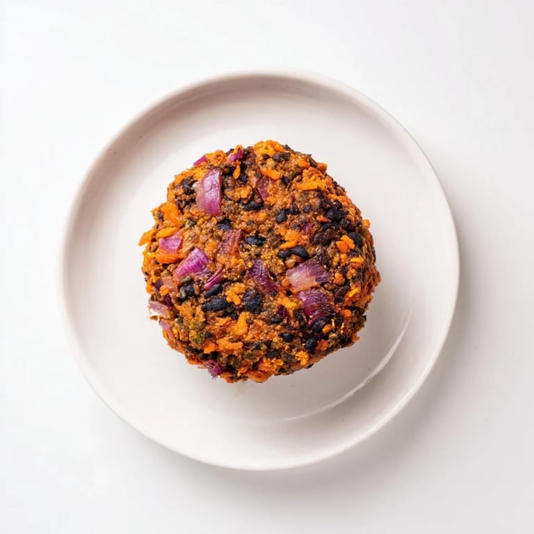 A close-up of a perfectly cooked, textured black bean burger, ready to be eaten on a bun.