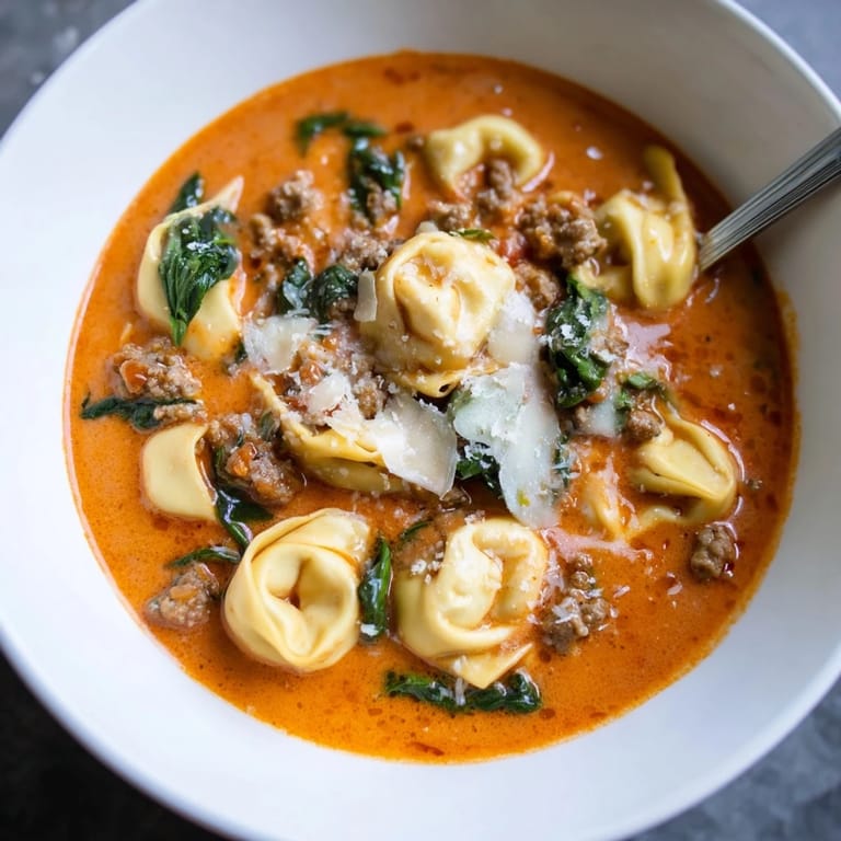 Warm Tuscan Tortellini Soup garnished with Parmesan, perfect with crusty bread for dipping.