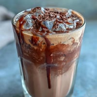 Velvety chocolate cream swirls atop chilled cold brew coffee, creating a decadent and refreshing drink.
